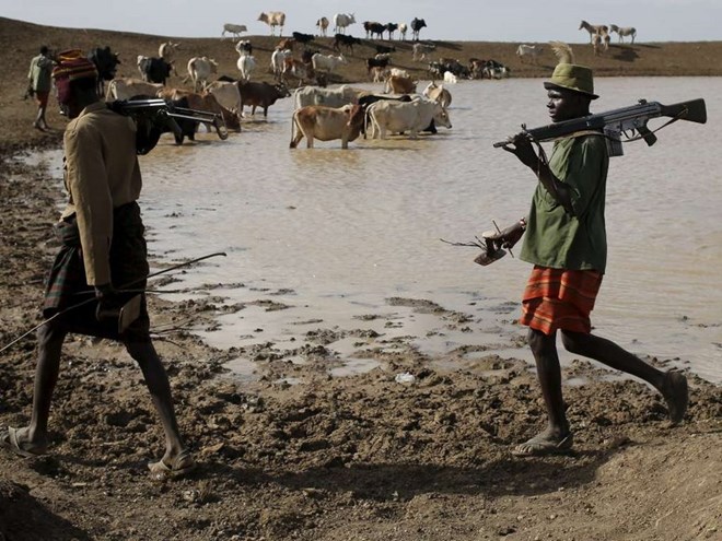 Turkana herdsmen carry rifles as they walk with cows near Baragoy, Kenya January 31, 2016 /FILE